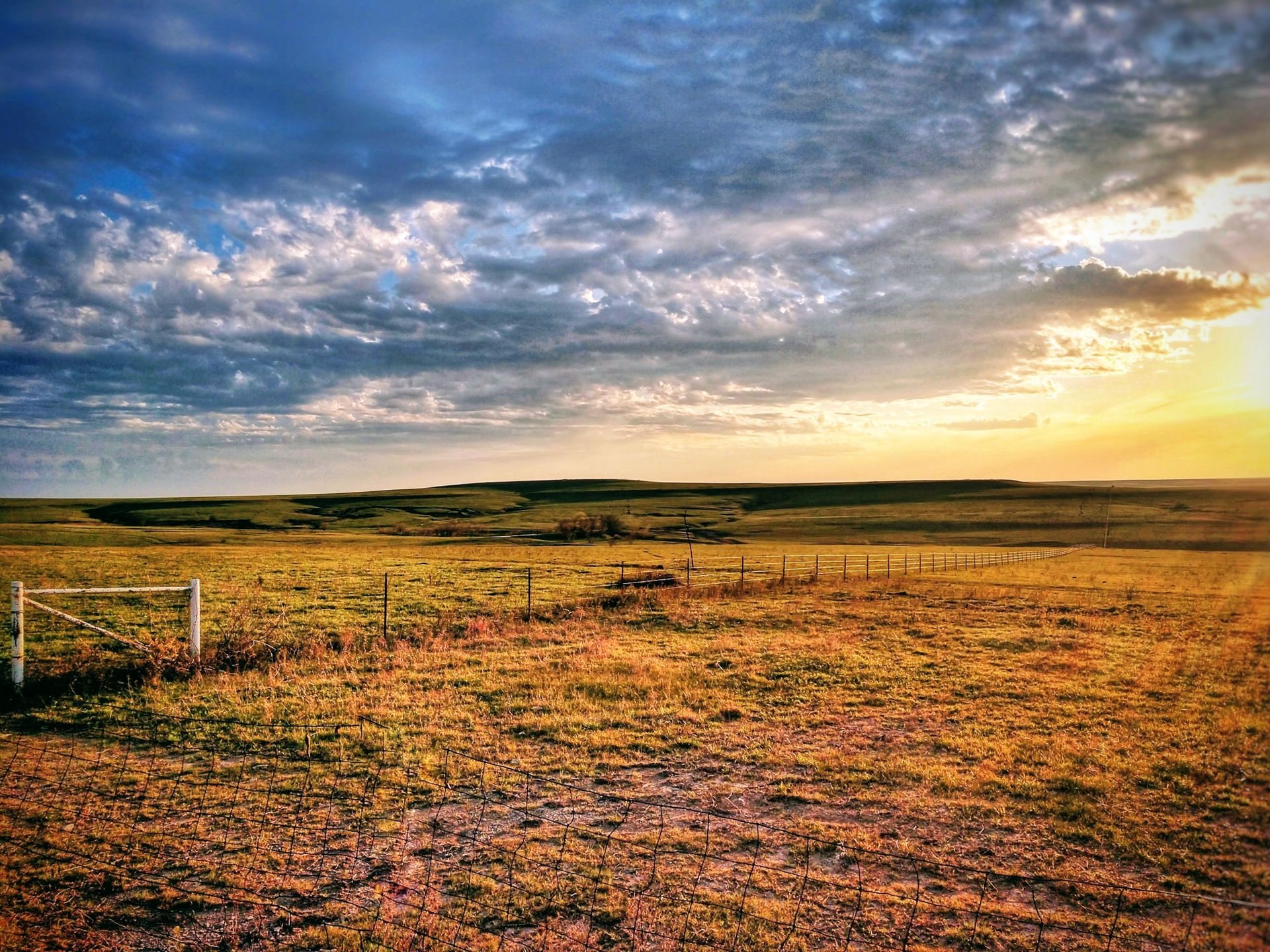 Sunrise over a fenced Kansas pasture